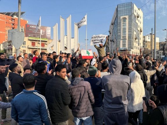 People gesture as a man holds the Syrian opposition flag, after Syrian rebels announced that they have ousted President Bashar al-Assad, in Tripoli, northern Lebanon December 8, 2024.