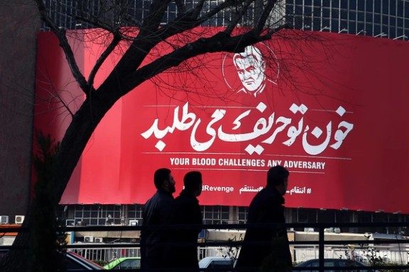 People walk past a billboard with a picture of Iranian Major-General Qassem Soleimani in Tehran