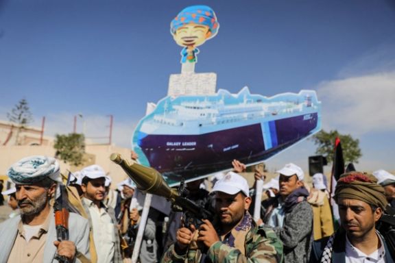Houthi followers hold a cutout banner, portraying the Galaxy Leader cargo ship which was seized by Houthis, Sanaa, Yemen, February 7, 2024.