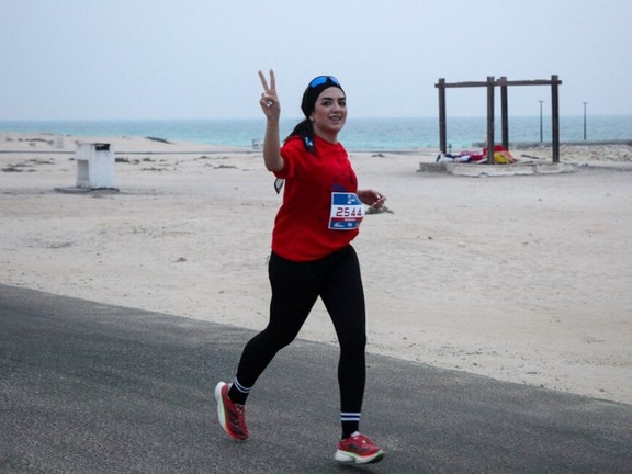 A young woman gestures towards camera while running the marathon in Iran's Persian Gulf island of Kish, December 5, 2025