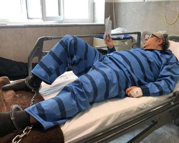 Jailed Iranian writer Baktash Abtin ankle cuffed to a hospital bed after contracting Covid-19 in prison. He died on January 8, 2022, at the age of 47.
