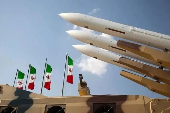 Iran-made Sejjil missile on display with Iranian flags in the background