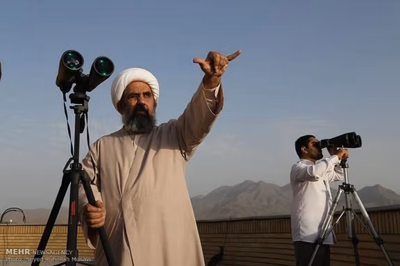 Clerics using binoculars to catch sight of the new crescent moon