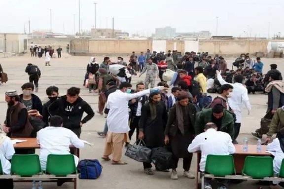 Afghan refugees at a border crossing waiting to enter Iran