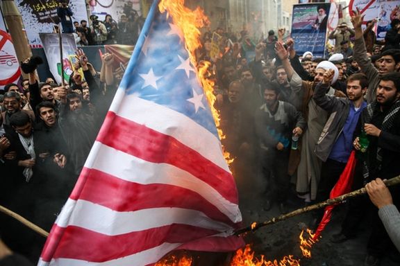 Pro-government protesters torch a US flag in Iran
