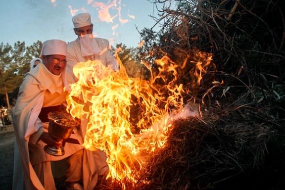 Zoroastrian fire priests lighting the Sadeh bonfire with embers from the holy fire