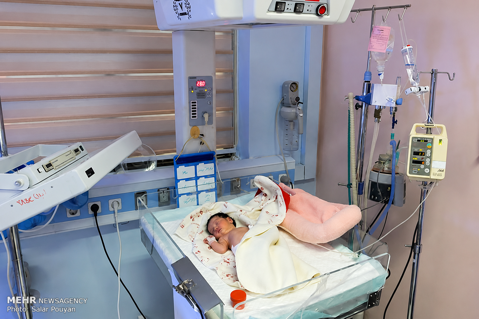 A newborn baby rests in a hospital neonatal care unit in Iran. 