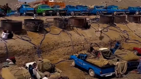 Nissan pickup trucks in Iran being loaded with gasoline for smuggling