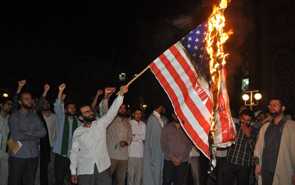 A seminary student in Qom burns a flag of the United States in October 2013, after President Rouhani's visit to New York.