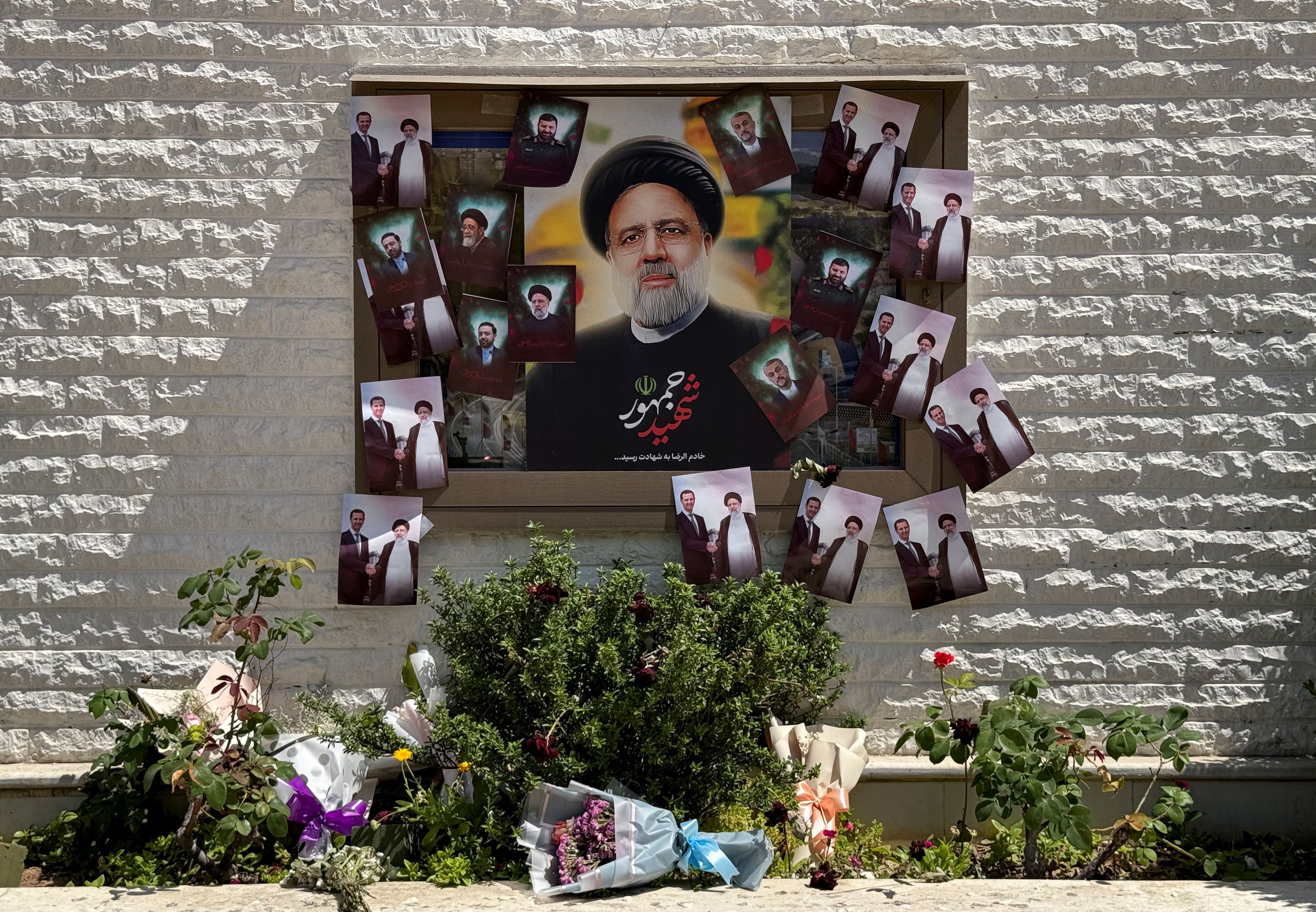 A poster depicting late Iranian President Ebrahim Raisi is seen among other pictures outside the Iranian embassy in Damascus, Syria May 22, 2024. 