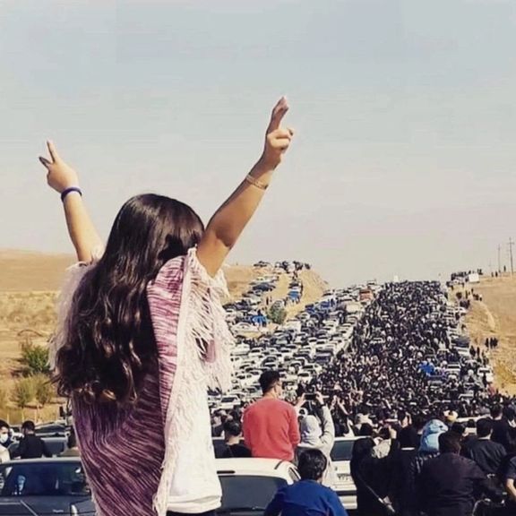A large crowd marching to a cemetery in the hometown of Mahsa Amini to pay tribute to her, on October 26, 2022