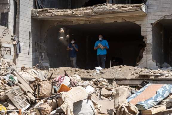 Men clear rubble from a Tehran home destroyed by Israeli bombing