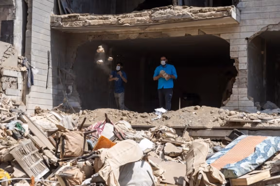 Men clear rubble from a Tehran home destroyed by Israeli bombing