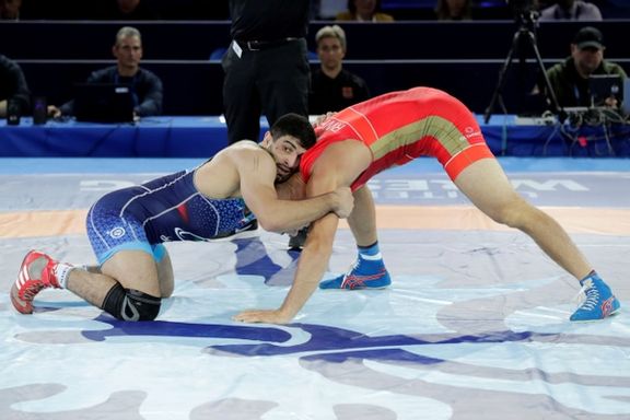 Iran's Kamran Ghorban Ghasempour in action with Russia's Magomed Guseinovich Kurbanov during the 92 kg final