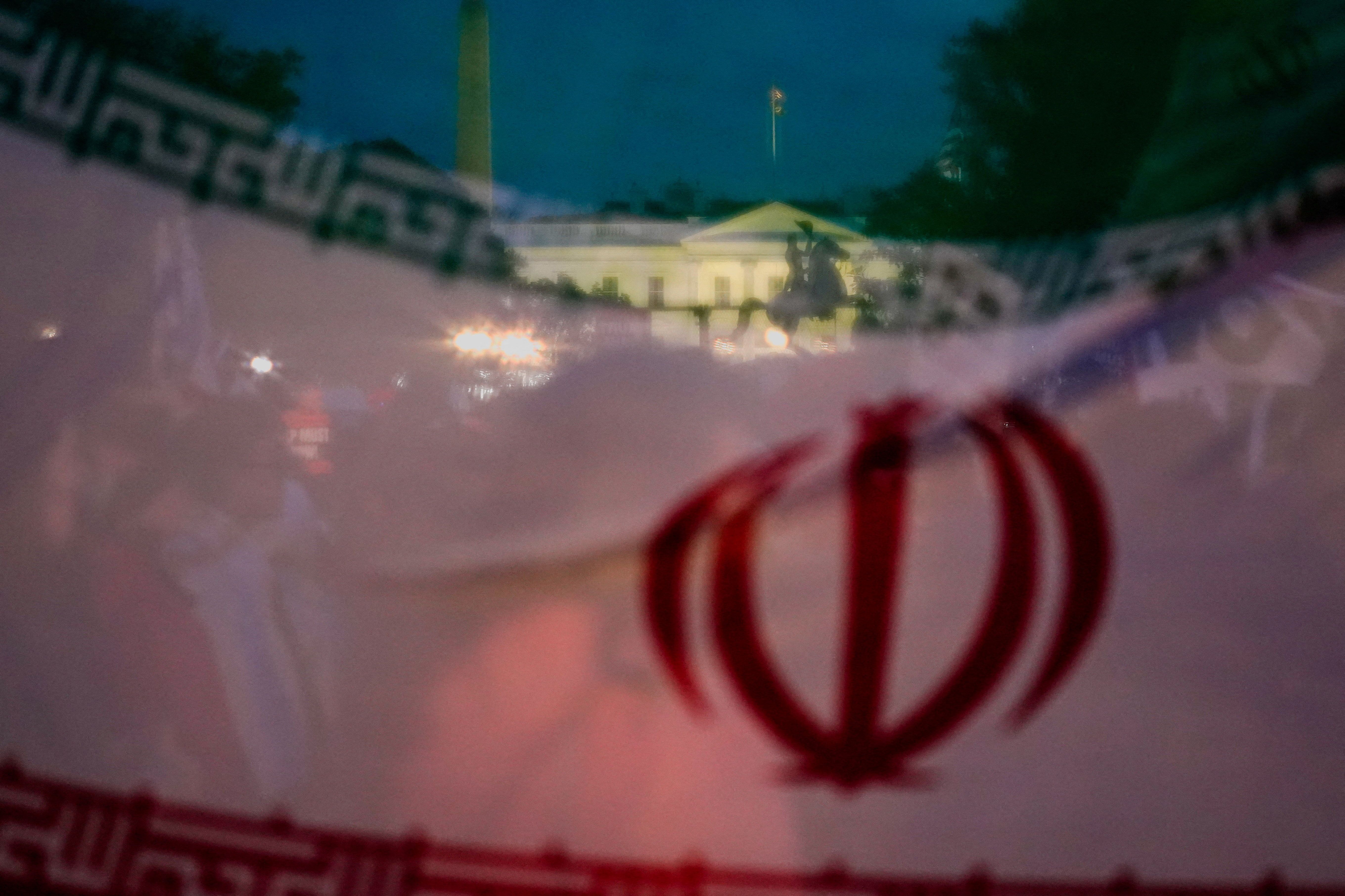 The White House is seen through Iran's flag during a protest against military action in Iran after US President Donald Trump said that he had agreed to a two-week ceasefire with Iran, less than two hours before his deadline for Tehran to reopen the Strait of Hormuz or face widespread attacks on its civilian infrastructure, outside the White House in Washington, DC, US, April 7, 2026. 