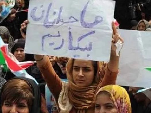A young woman in Iran holding a sign saying "We the youth are unemployed". Undated