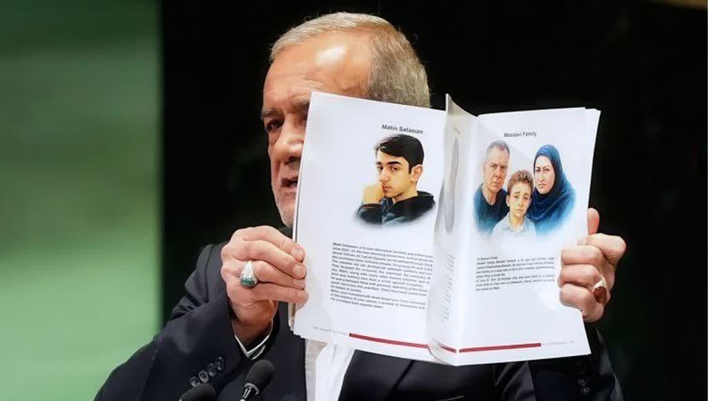 Pezeshkian holds up a booklet containing biographies of Iranians killed by Israel in a June war during his speech before the UN.