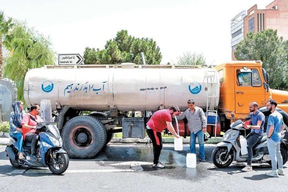 مردانی که ظروف را از یک کامیون آب ، تهران ، ایران ، ژوئیه 2025 پر می کنند