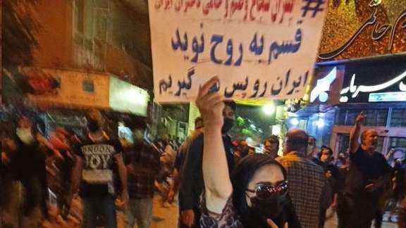 A woman with headscarf in Tehran vows to continue protests carrying a placard that says, "We will take back Iran". Oct. 15, 2022