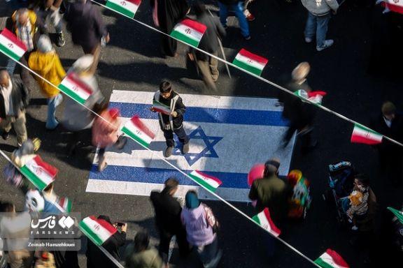 A boy stands on an Israeli flag painted on a street during regime-sponsored demonstrations to mark the 45th anniversary of Islamic Republic establishment, Tehran, February 11, 2024