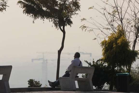 A man sits in a park, following the increase in air pollution in Tehran, Iran, November 22, 2025.