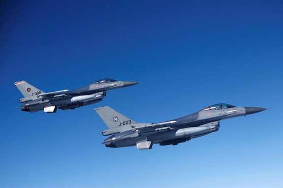 Netherlands' Air Force F-16 fighter jets fly alongside an aircraft simulating aerial interceptions during a media day on July 4, 2023