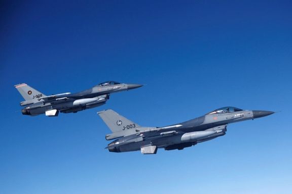 Netherlands' Air Force F-16 fighter jets fly alongside an aircraft simulating aerial interceptions during a media day on July 4, 2023