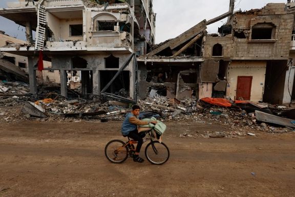 A Palestinian rides a bicycle next to the rubble of a house hit in an Israeli strike during the conflict, amid a temporary truce between Hamas and Israel, in Khan Younis in the southern Gaza Strip November 27, 2023.