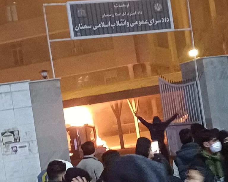 Protesters gather outside the Public and Revolutionary Prosecutor's Office in Semnan, east of Tehran, as a fire burns inside the compound during Iran's January 2026 uprising.