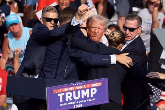 Republican presidential candidate and former US President Donald Trump gestures with a bloodied face while he is assisted by US Secret Service personnel after he was shot in the right ear during a campaign rally at the Butler Farm Show in Butler, Pennsylvania, US, July 13, 2024.