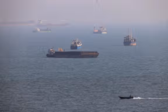 Commercial vessels are seen in waters near the Strait of Hormuz amid ongoing negotiations over shipping arrangements and the reopening of the waterway.