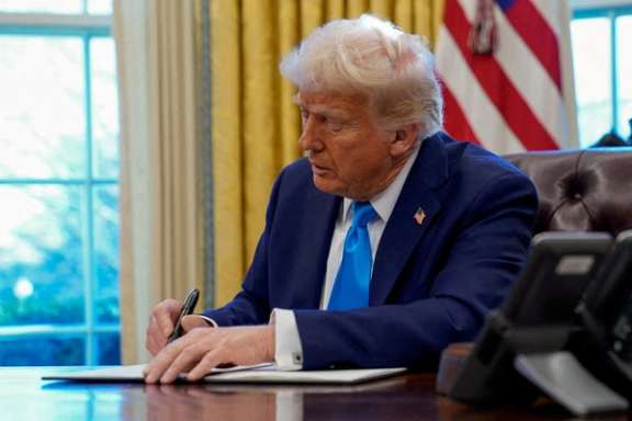 US President Donald Trump signs a document in the Oval Office at the White House in Washington, February 4, 2025.