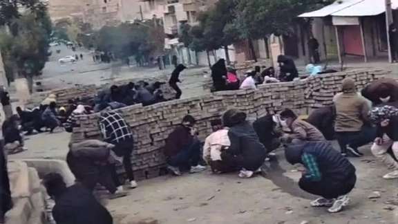 Kurdish civilian protesters hiding behind a makeshift barricade on Nov, 19, 2022