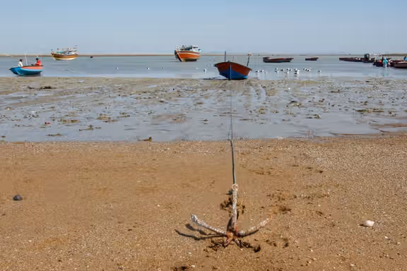 Fishing boats sit grounded at low tide along the coast in the southeastern Iranian port of Konarak, July 20, 2026