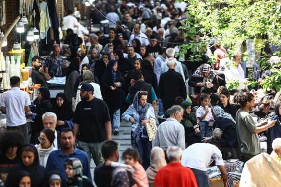 People walk in a busy street near Tehran's Grand Bazaar, April 21, 2026