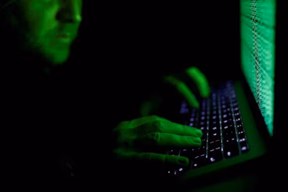 A man types on a computer keyboard in front of the displayed cyber code in this illustration picture taken on March 1, 2017.