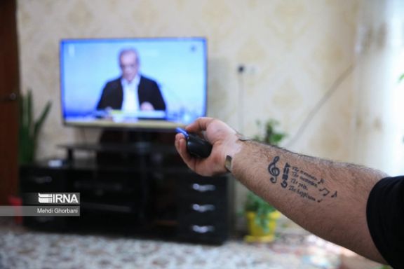 An Iranian man watching a presidential debate in Tehran (June 2024)