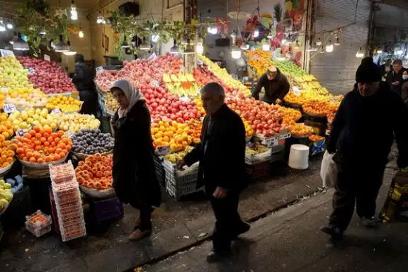 FILE PHOTO: People walk through a local market as the value of the Iranian rial drops, in Tehran, Iran, December 20, 2025. / WANA via Reuters