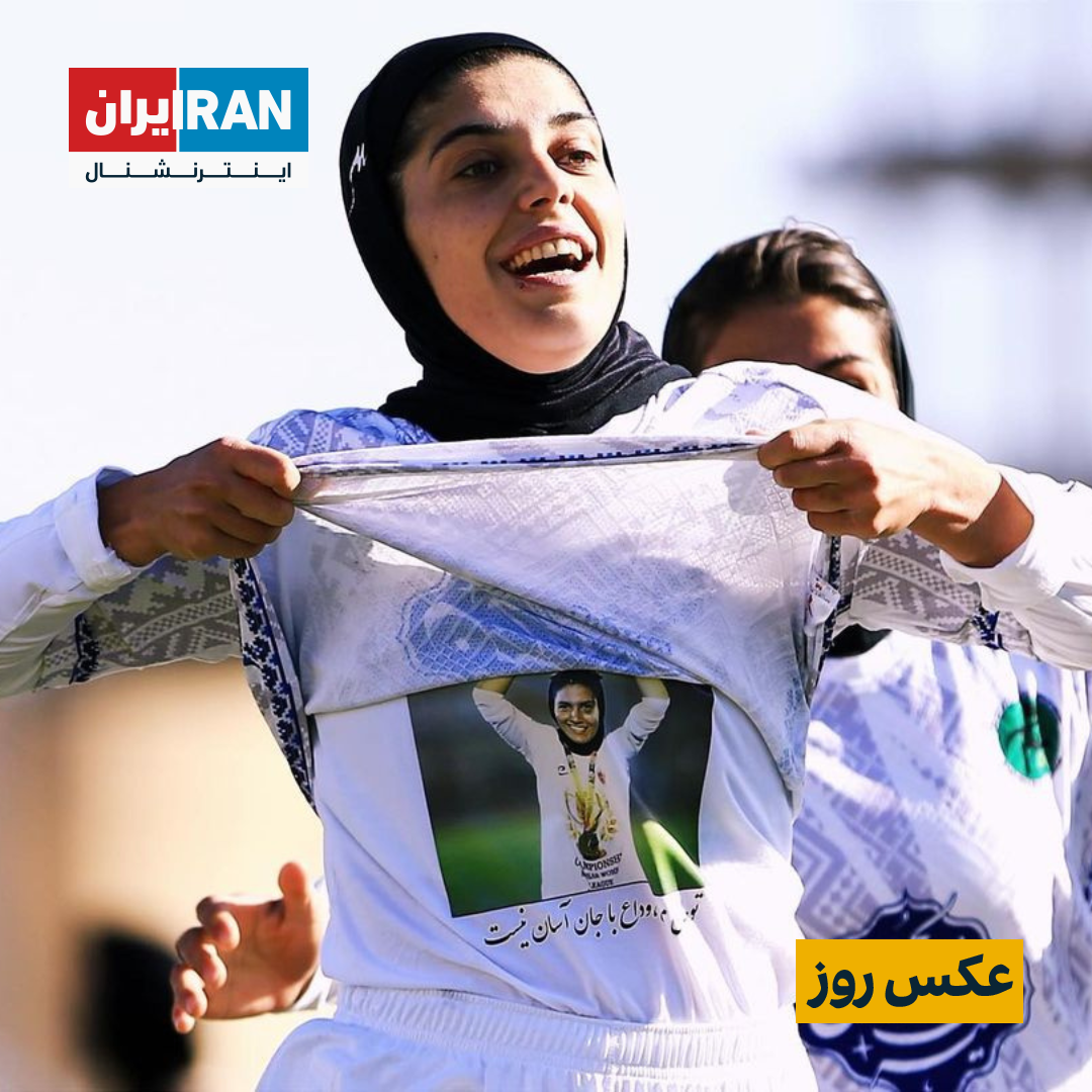 a woman takes off her shirt with a picture of a soccer player on it