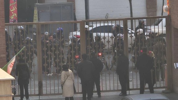 Security forces stand behind a gate outside Sina Hospital in Tehran, where witnesses said some protesters had sought refuge during clashes, January 6, 2026