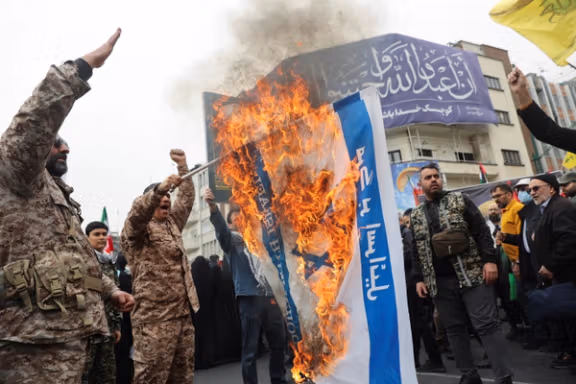 A person holds a burning banner depicting Israeli flag as Iranians take part in a protest marking the annual al-Quds Day (Jerusalem Day) on the last Friday of the holy month of Ramadan in Tehran, Iran, March 28, 2025.