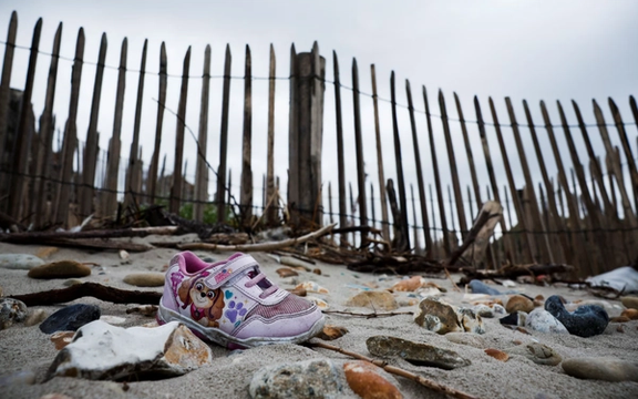 لنگه کفش باقیمانده از یک کودک مهاجر در سواحل منطقه ویمرو، فرانسه، ۱۴ شهریور