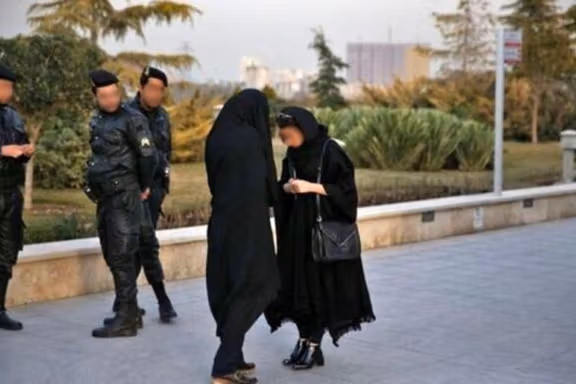 A hijab enforcer team confronting a woman on streets