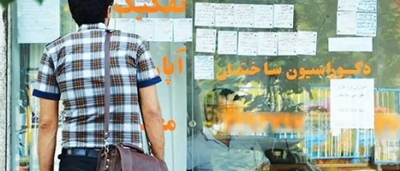 A young man checking the rents in front of a real estate office in Tehran