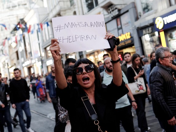 A demonstrator shouts slogans while holding up a sign during a protest in solidarity with women in Iran in central Istanbul, Turkey September 20, 2022.