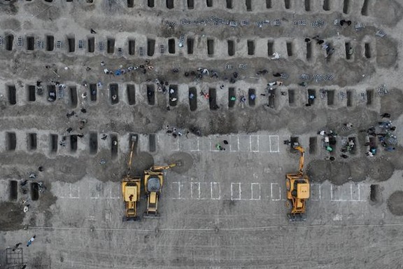 An aerial view of construction vehicles digging rows of graves for victims of a strike on a girls school in Iran's southern city of Minab, March 2, 2026
