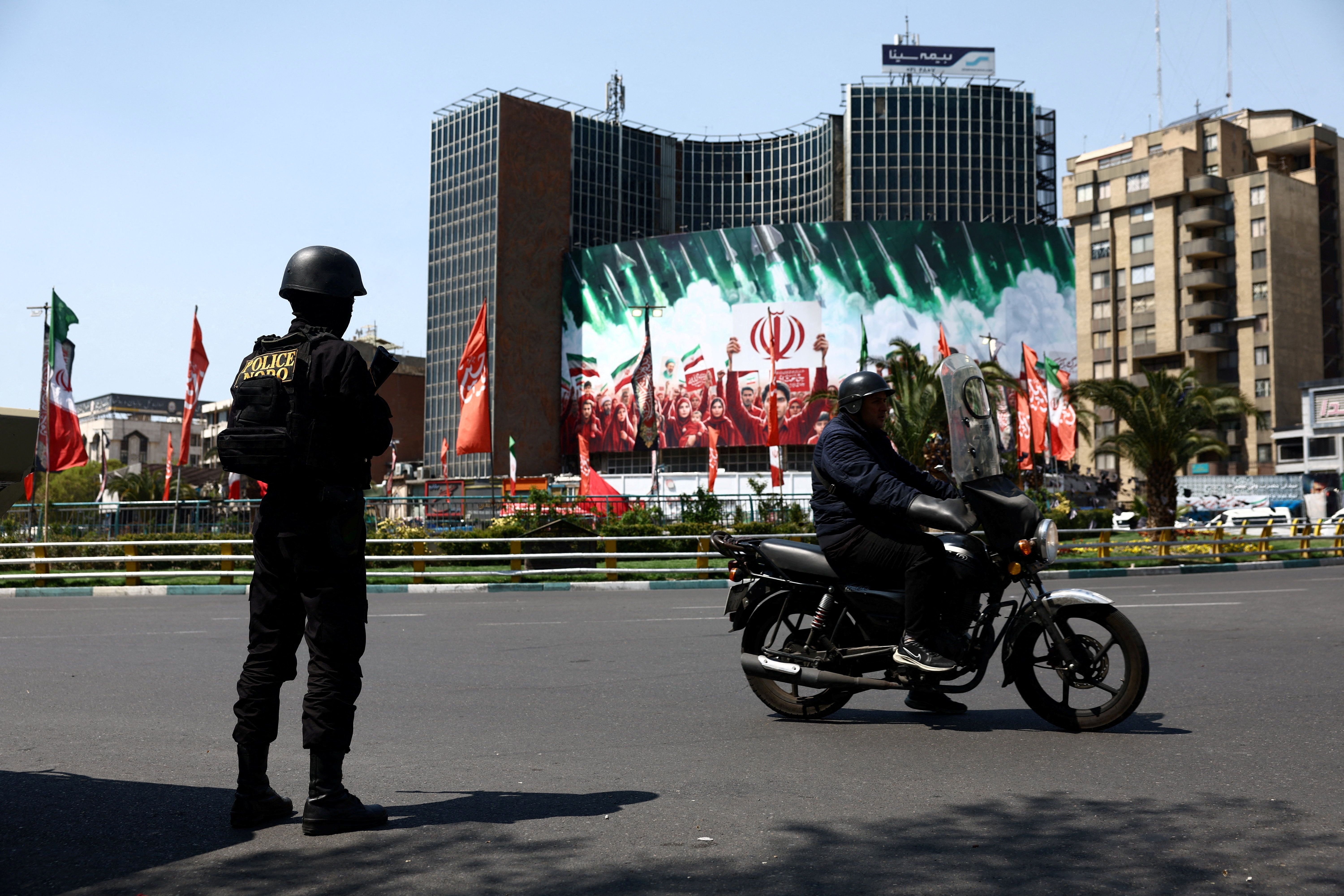 A member of a police force stands guard on a street in Tehran, Iran, on April 1, 2026. 
