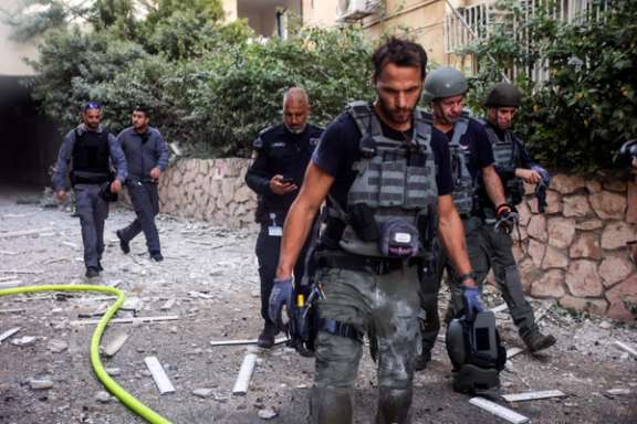Israeli security officials work as rockets are launched from the Gaza Strip, in Tel Aviv, October 7, 2023.