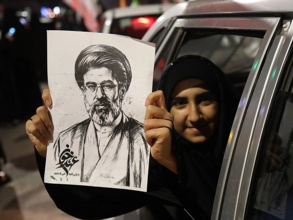 A female loyalist holds a print of Iran's new supreme leader Mojtaba Khamenei in the northeastern city of Mashhad, March 7, 2026