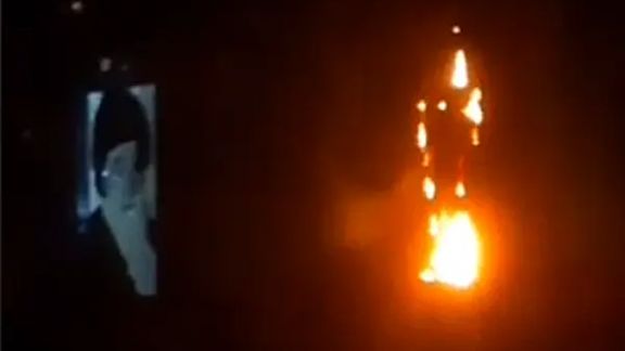 Screen grab from a video showing Ayatollah Khomeini's statue on fire in Qom